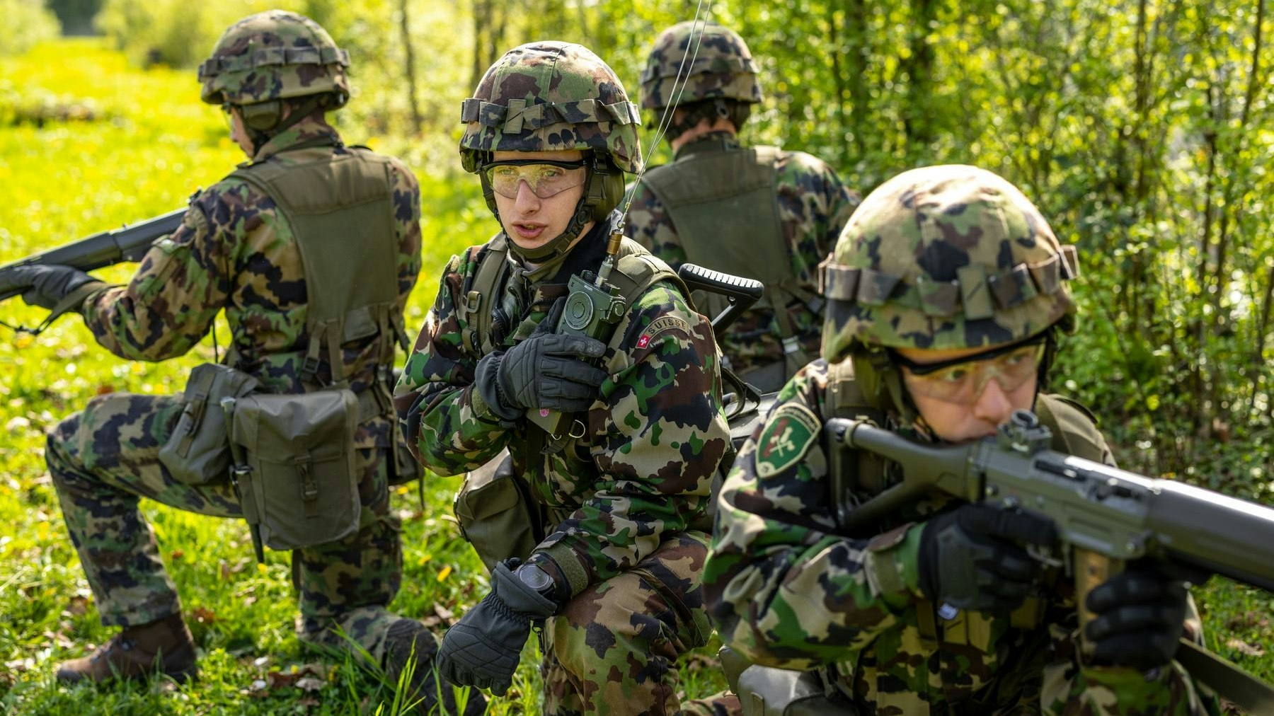 Diversi Soldati posizionati in un'area aperta e boscosa.