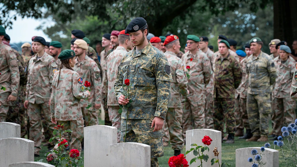 Ein Angehöriger des Österreichischen Bundesheers legt auf dem Soldatenfriedhof in Groesbeek eine Rose nieder.