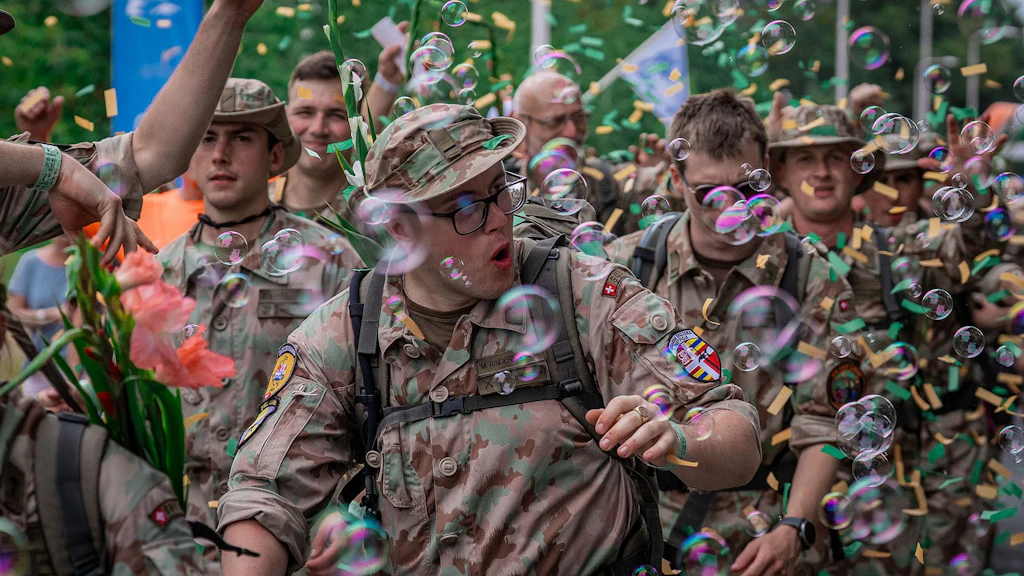Inmitten von Seifenblasen und Konfetti: Marschierende werden von tausenden Menschen motiviert.