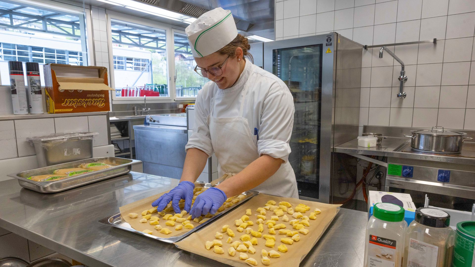 Mitten im lebendigen Küchenalltag: Anne Pellaton, Kochlernende im ersten Lehrjahr, bei der sorgfältigen Produktion frischer Gnocchi.