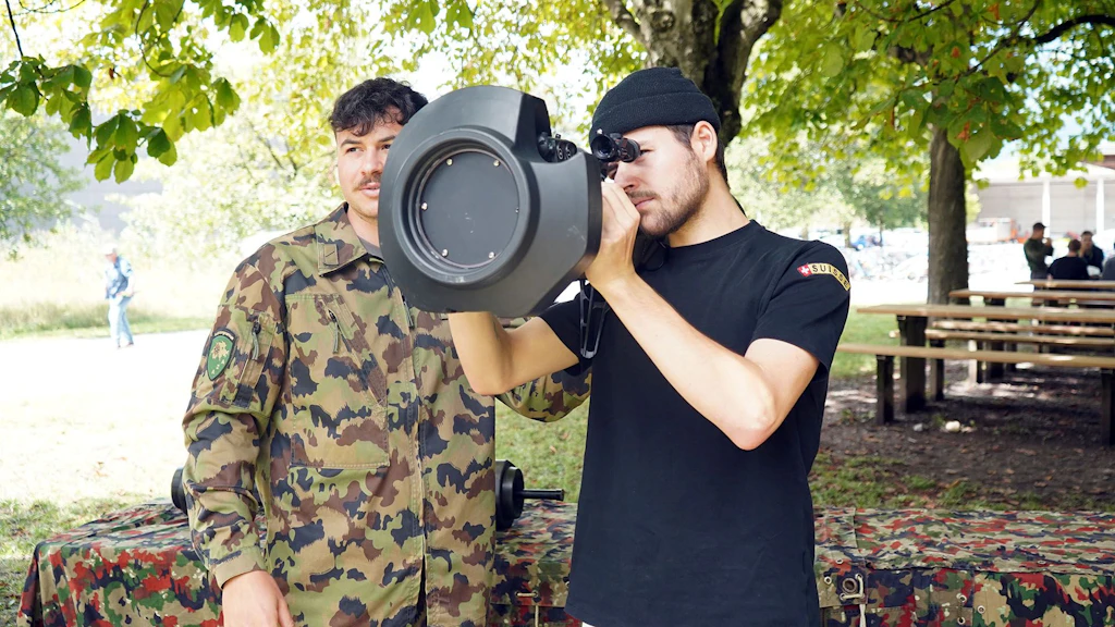 Armeeangehöriger und Zivilist mit Panzerabwehrwaffe.
