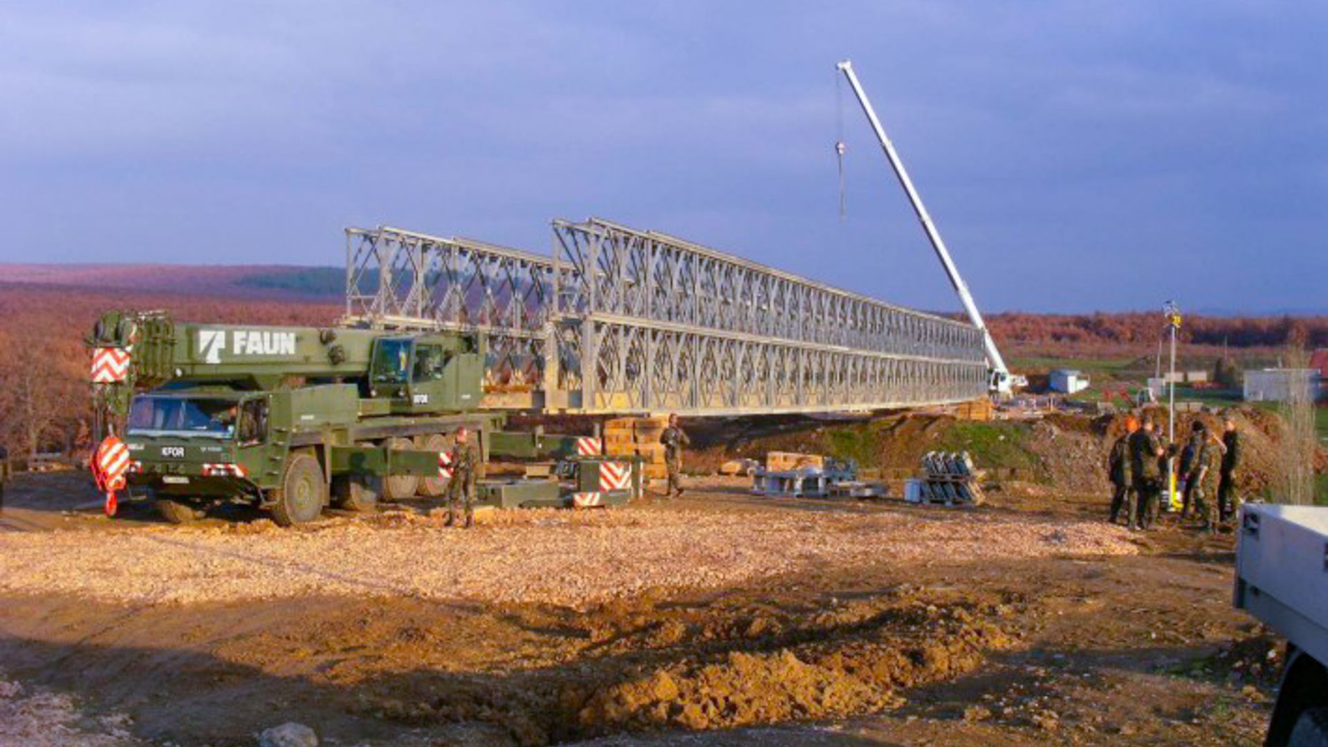 Au début de l'engagement de la SWISSCOY, l'accent était mis sur la reconstruction après la guerre. Cela comprenait entre autres la construction de ponts pour assurer la liberté de mouvement de la KFOR. Des systèmes de ponts ont été utilisés à cet effet, systèmes qui ont ensuite également été introduits dans l'armée suisse et qui ont par exemple été utilisés lors des intempéries au Tessin en 2024.