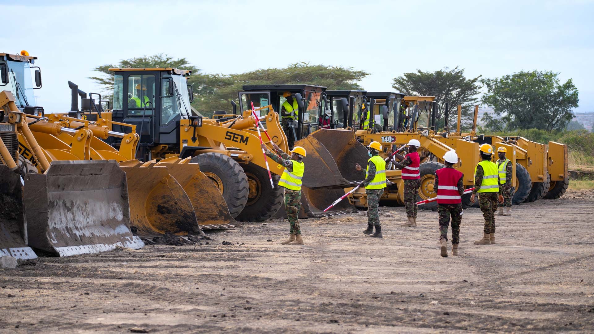 Avec l’aide des instructeurs, les machines de chantier sont contrôlées et préparées avant le travail.