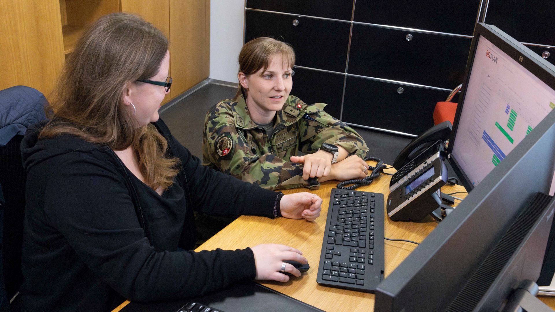 Nathalie Rölli, sof carr pl armes, discute avec Debora Rickenbacher, collaboratrice à l’AMZ, de ses saisies sur l’outil de gestion de l’occupation « BELPLAN ». Il s’agit de coordonner l’utilisation de l’infrastructure et la gestion des clés.
