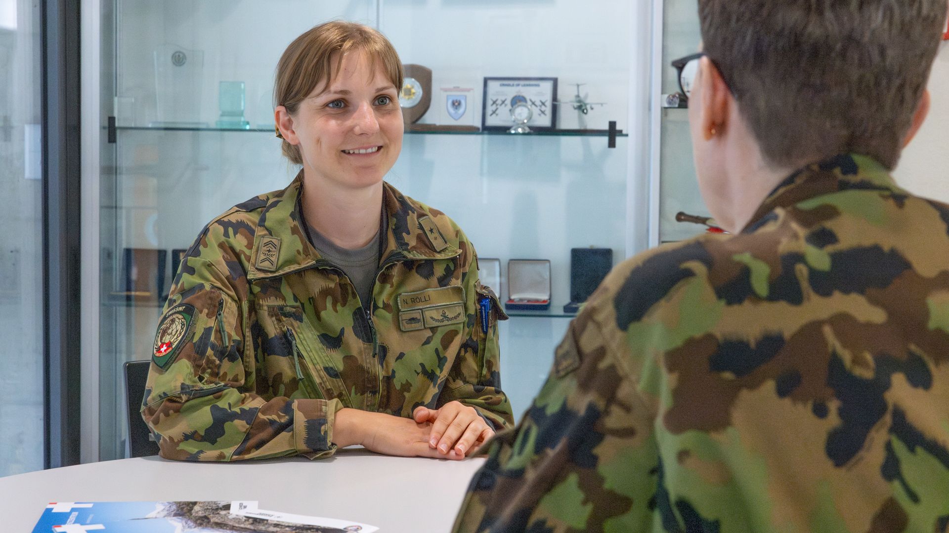 L’aiut SM Nathalie Rölli illustra i propri compiti all’uff spec Aisha Seitz.