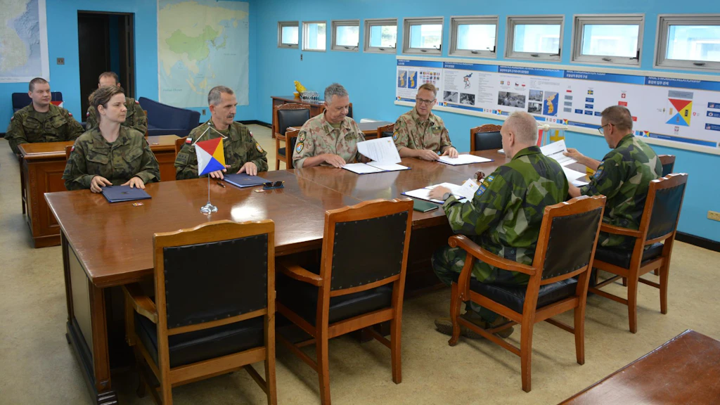 Due volte all’anno a Panmunjom si tiene il NNSC Plenary Meeting, al quale partecipa anche la delegazione polacca. Al centro dell’immagine si possono vedere seduti i capi della delegazione svizzera e di quella svedese nonché il vicecapo della delegazione polacca, colonnello Aleksander Martyszunis, affiancati dai loro segretari.